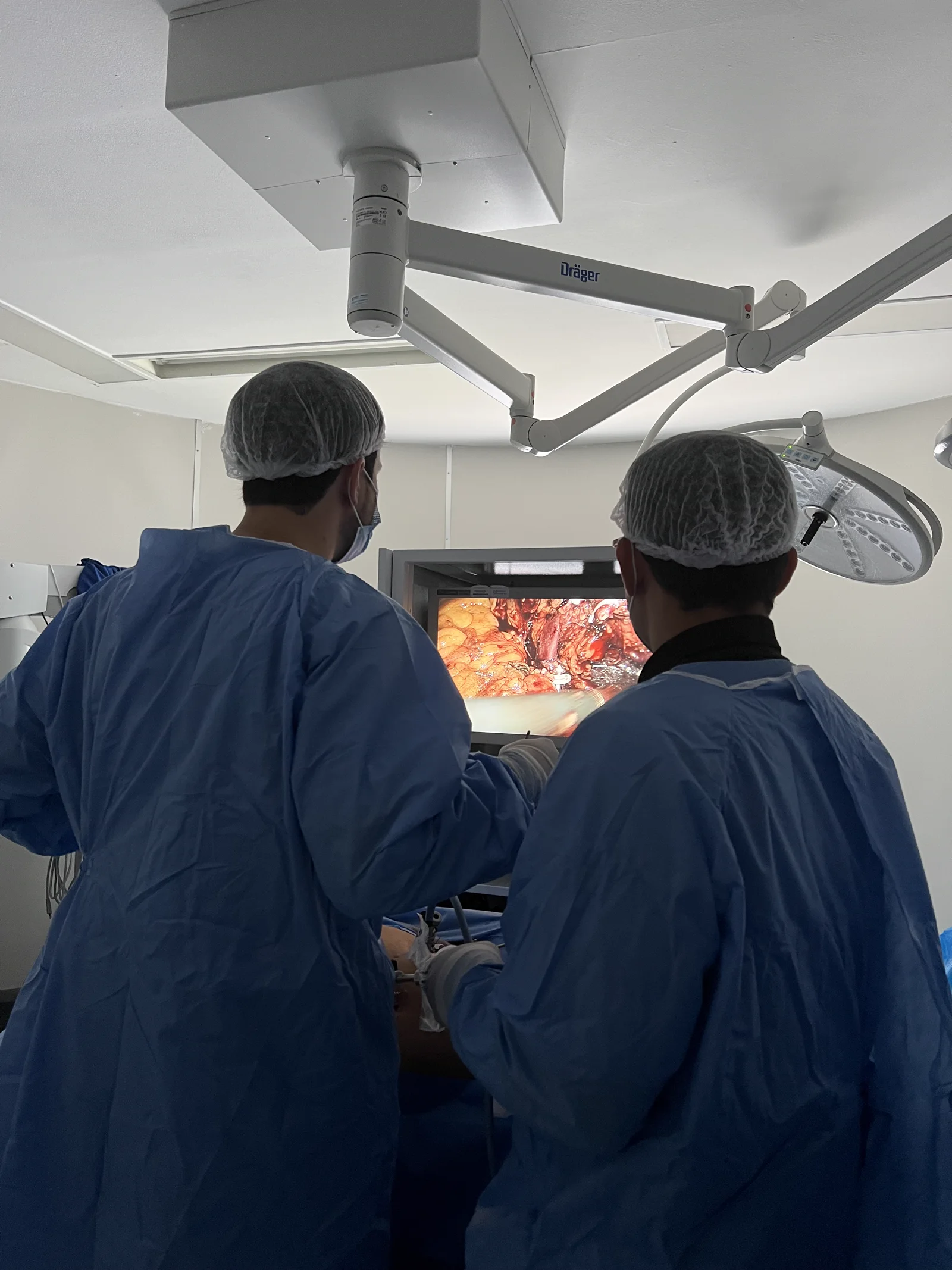 Equipe médica acompanhando uma cirurgia minimamente invasiva por vídeo