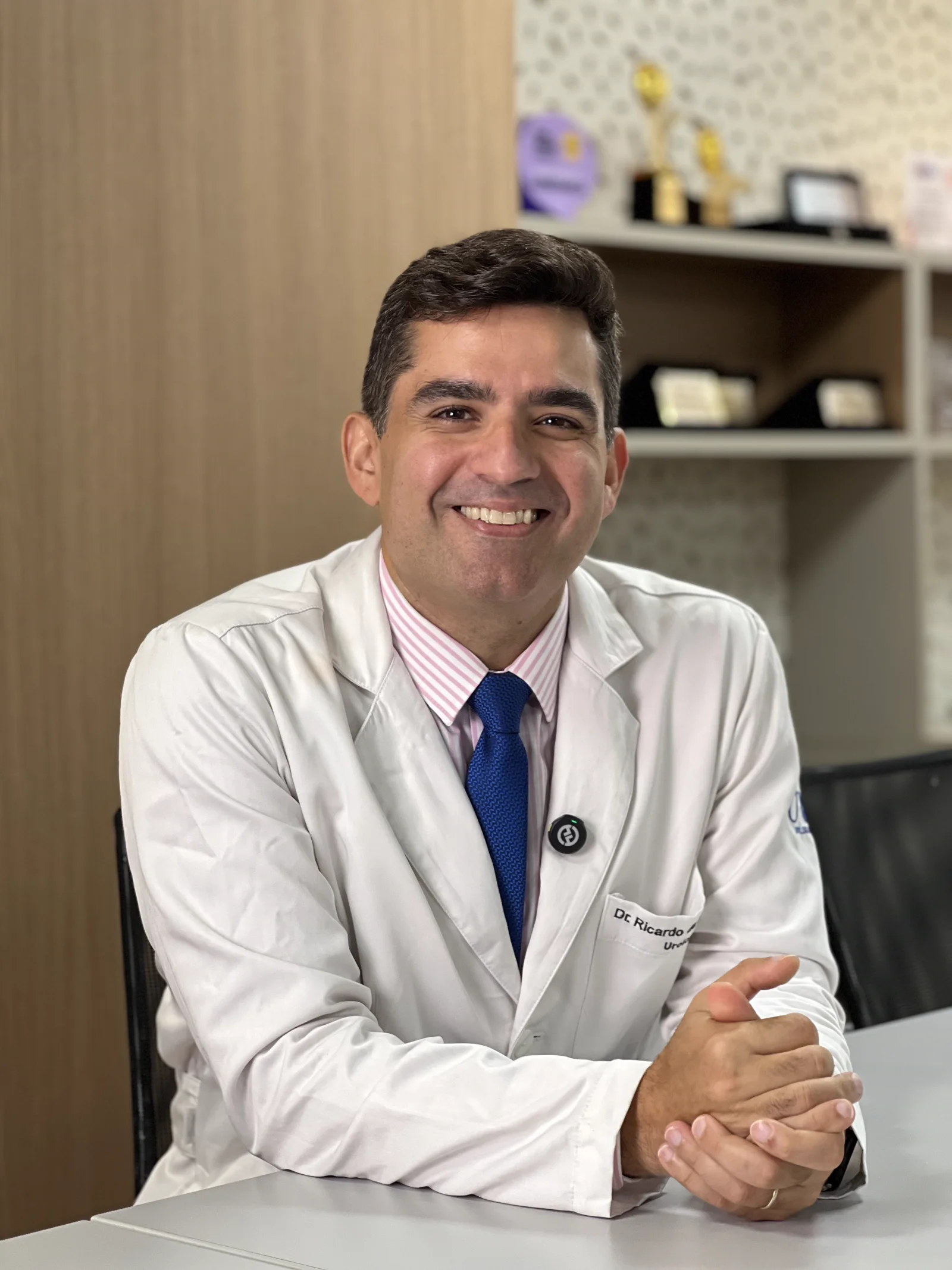 Dr. Ricardo Freitas, urologista em Salvador, sorrindo em seu consultório